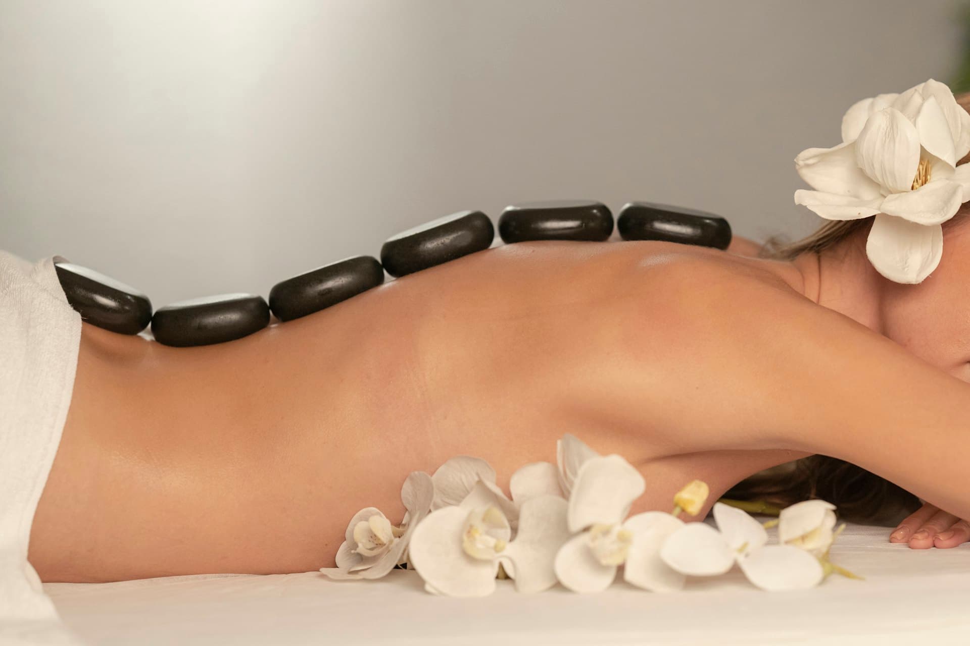 Smooth basalt stones resting along a guest's back during a hot stone massage