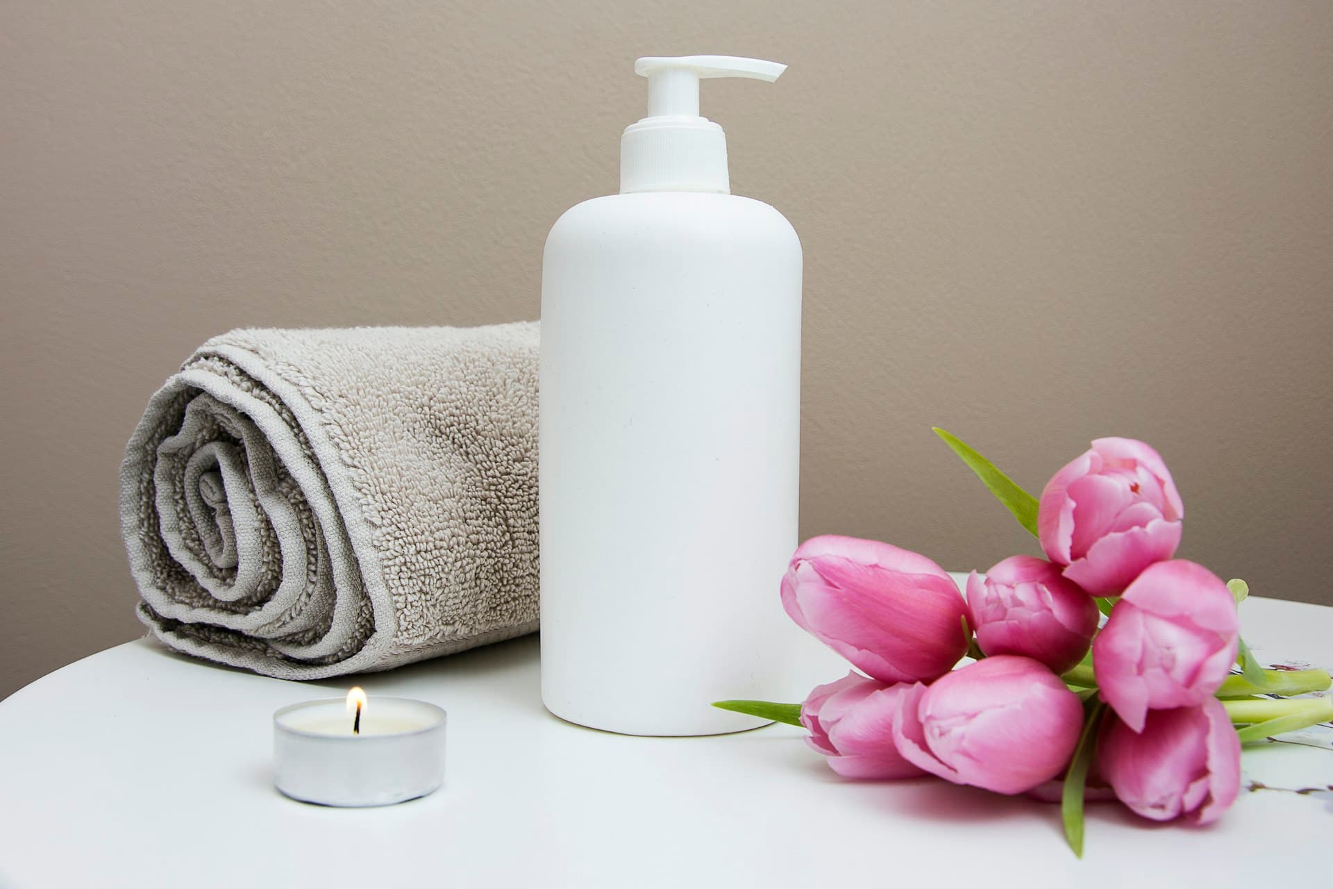 Soft towels and aromatic oils arranged in warm light